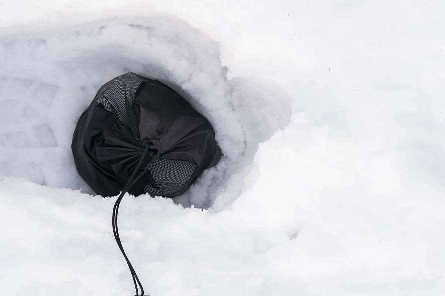 Когда не хватает кольев для фиксации оттяжек можно использовать небольшой мешочек, чехол от палатки. Главное иметь на оттяжке небольшой карабин Альтернативный вариант фиксации оттяжек на палатке зимой