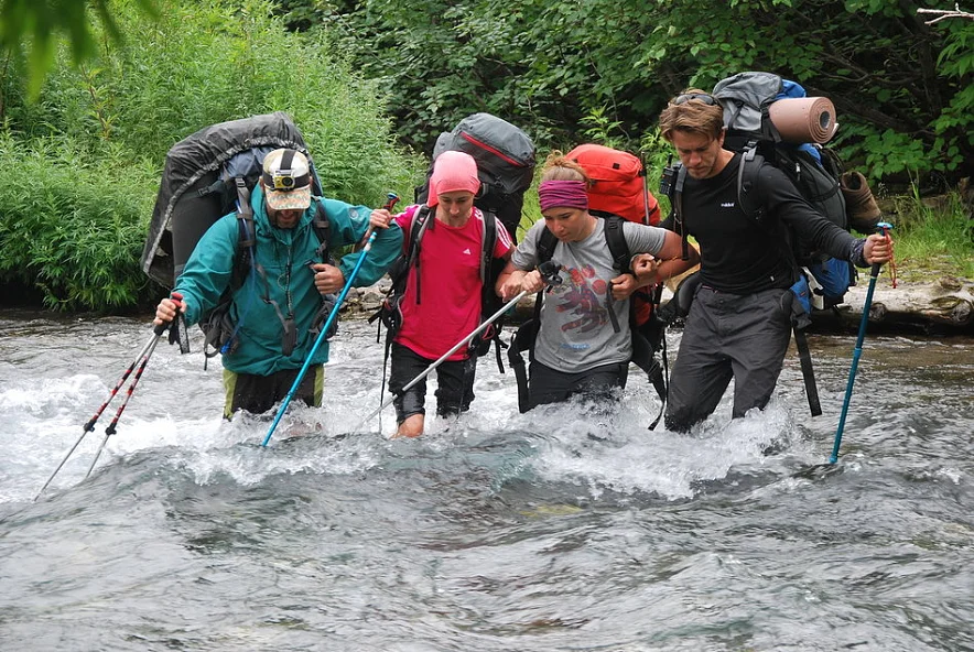 Группа туристов переходит реку вброд